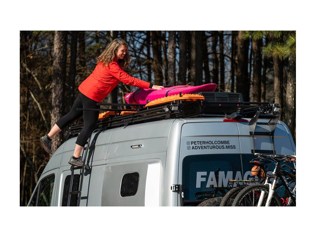 Kathy placing kayak on Black River Dual Roof Rack