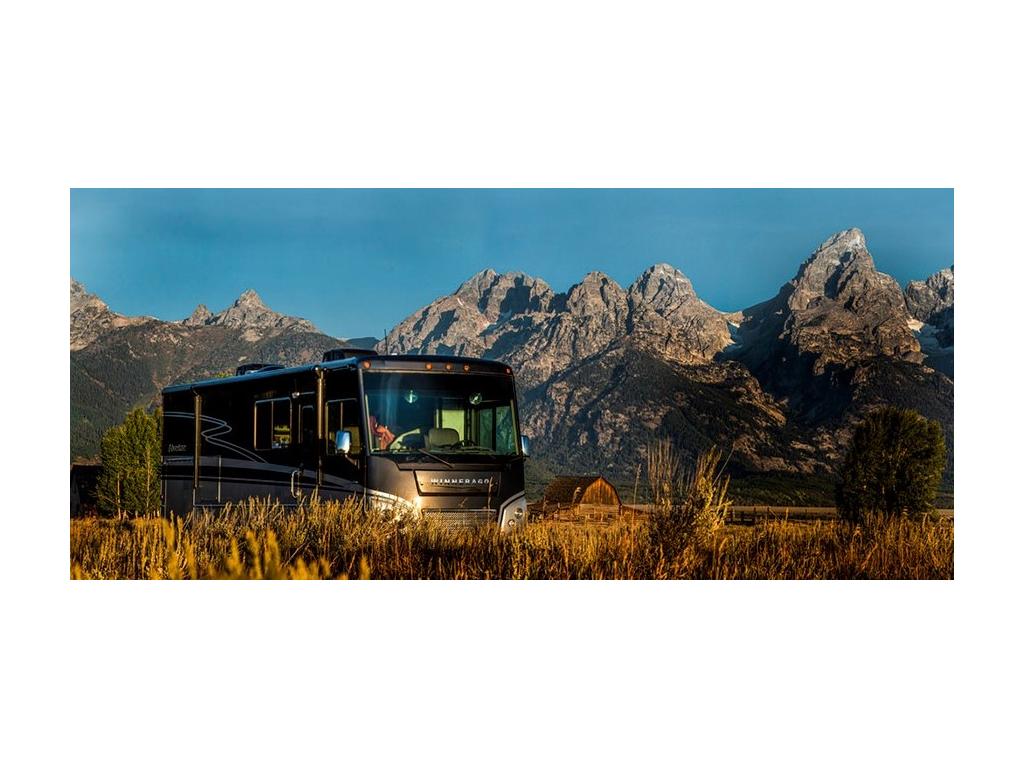 Adventurer sounded by yellow grass and tall mountains with barn in far distance
