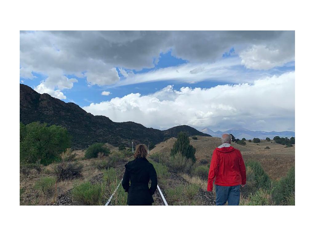 Alyssa and another person walking down the road towards mountains