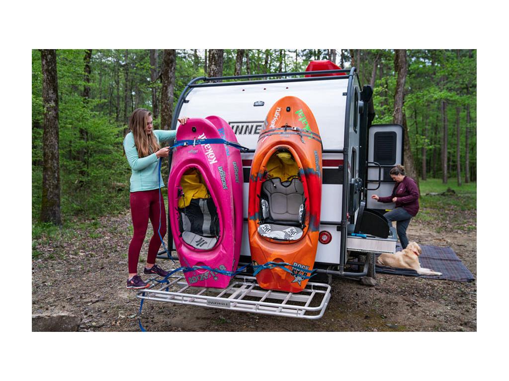 Kathy stepping inside HIKE while Abby is on back strapping in kayaks