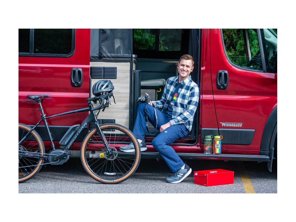 Mikah sitting in entry of Solis holding camera with bike nearby