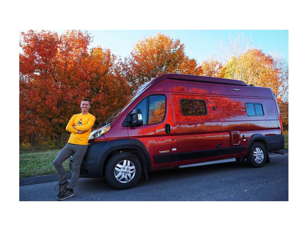 Mikah leaning against bumper of Winnebago Solis