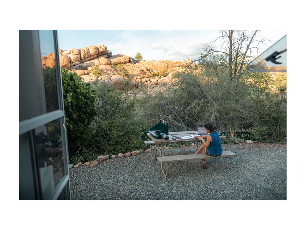 Nadia sitting outside of Trend working on laptop at picnic table