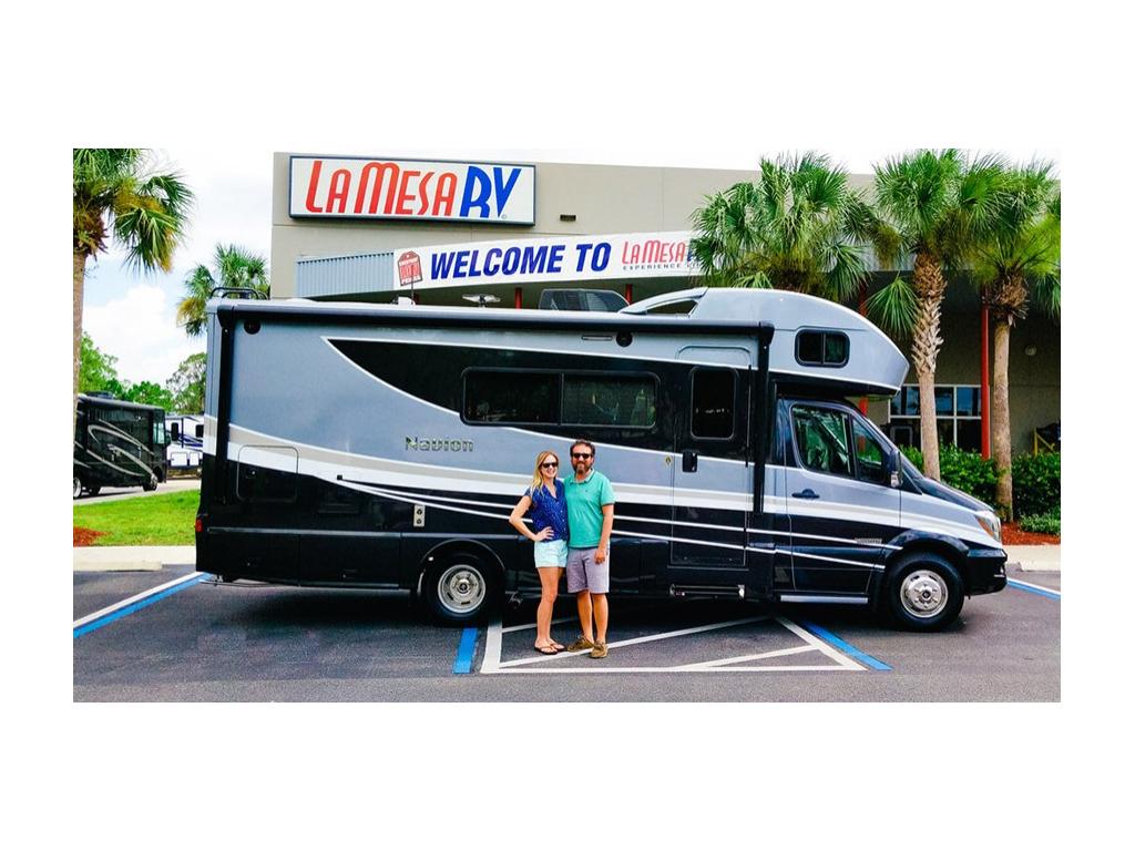 Katelyn and Howard smiling in front of Navion at La Mesa RV