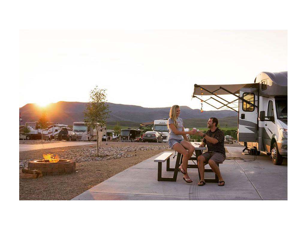 Lindsay and Dan having drinks at picnic table outside of Winnebago Navion