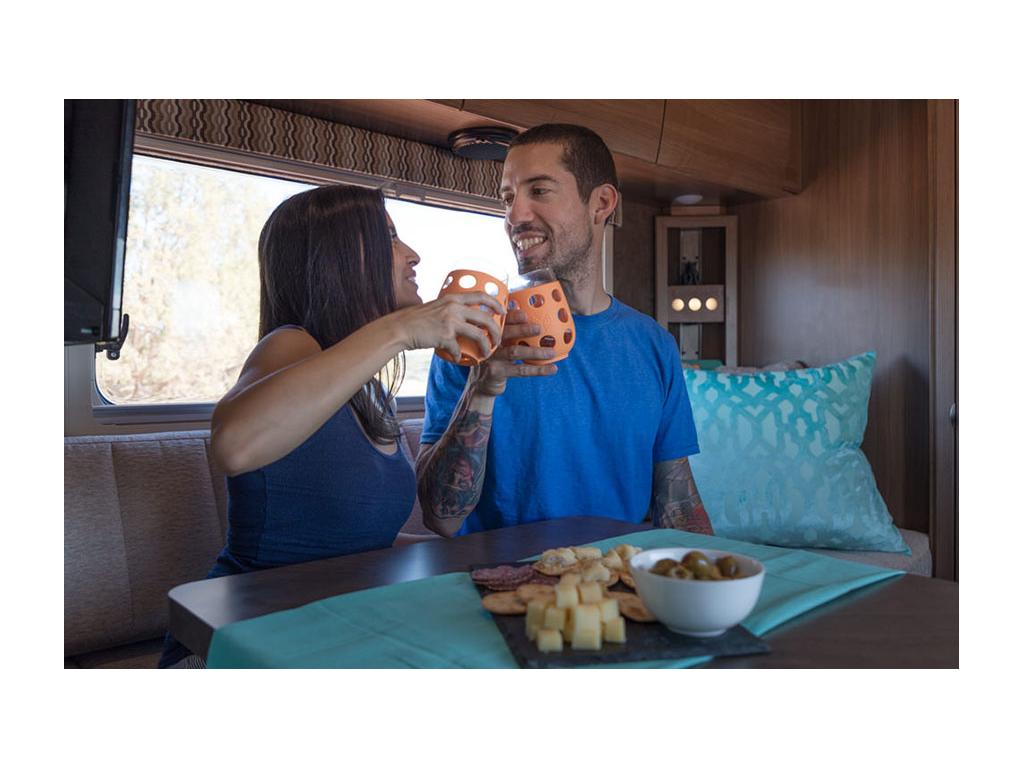 Nadis and Jon drinking wine at dinette with plate of cheese on table