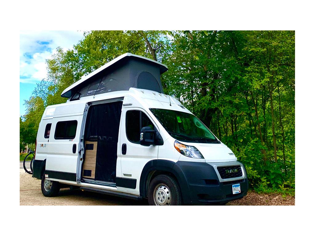 Winnebago Solis parked next to trees with pop-top up