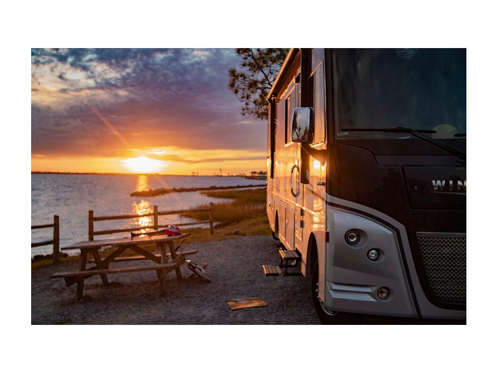 Adventurer parked near water at sunset