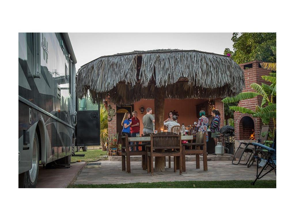 Seven people talking on the patio next to the Journey