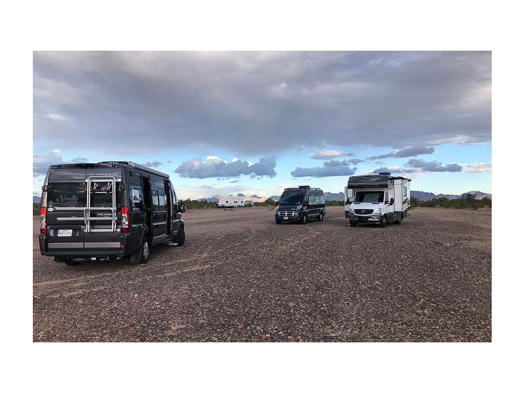 Two Travatos and a Vita parked on gravel