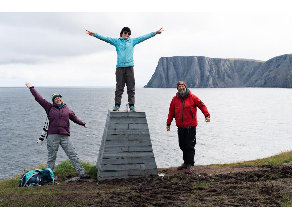 The Holcombe family standing at edge of shore with water in the background