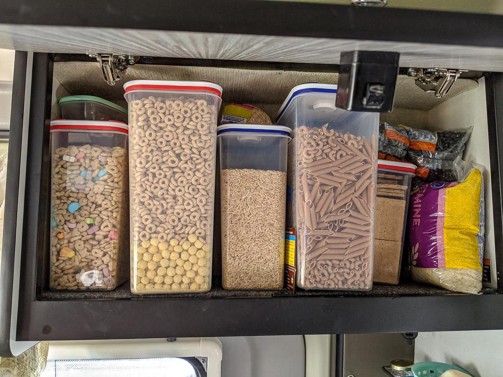 Overhead bin with containers of dry cereal