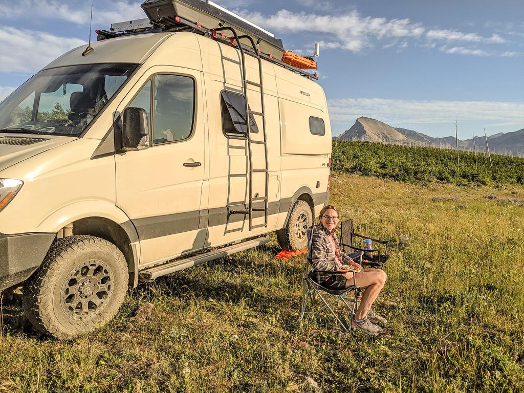 Kelly sitting in lawn chair next to Revel in grass