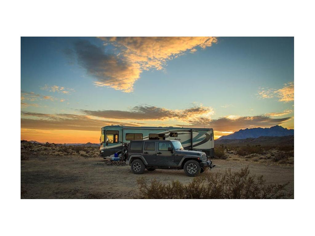 Journey and tow can parked in rocky desert