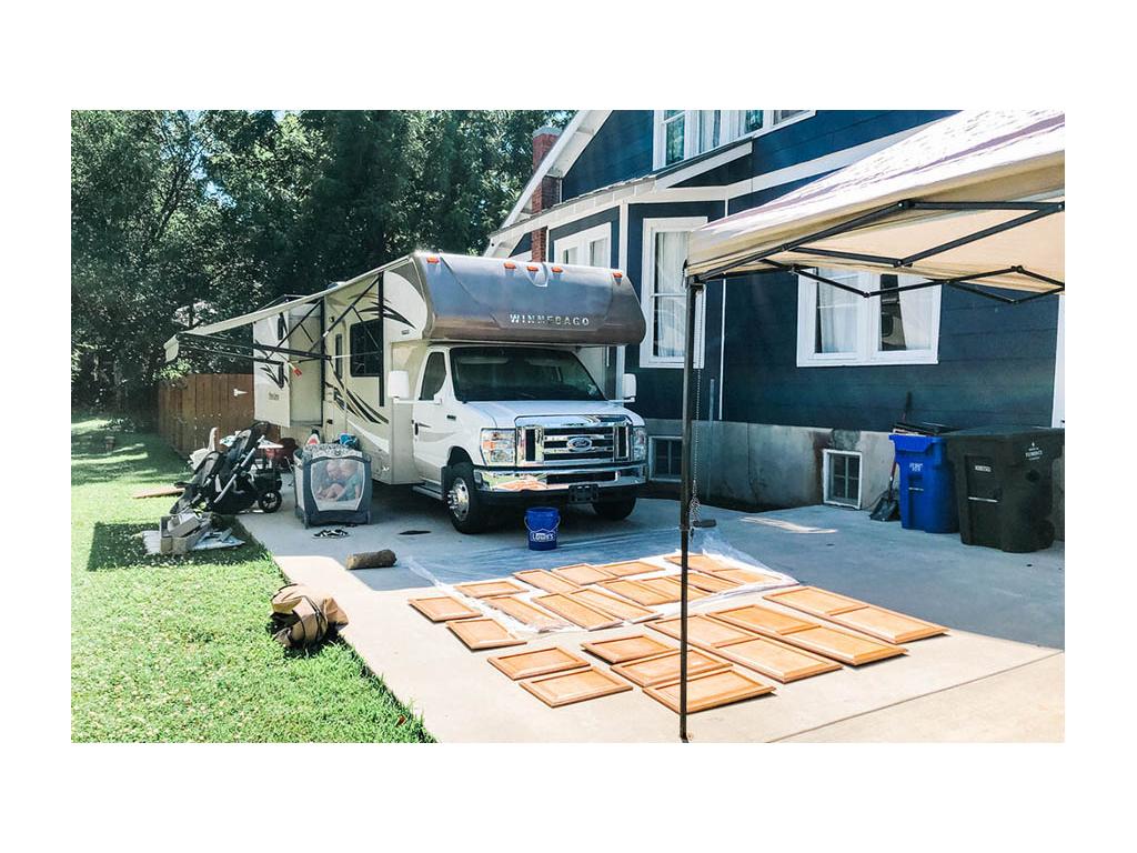 Cabinet doors laid out on driveway next to Minnie Winnie ready to be painted.