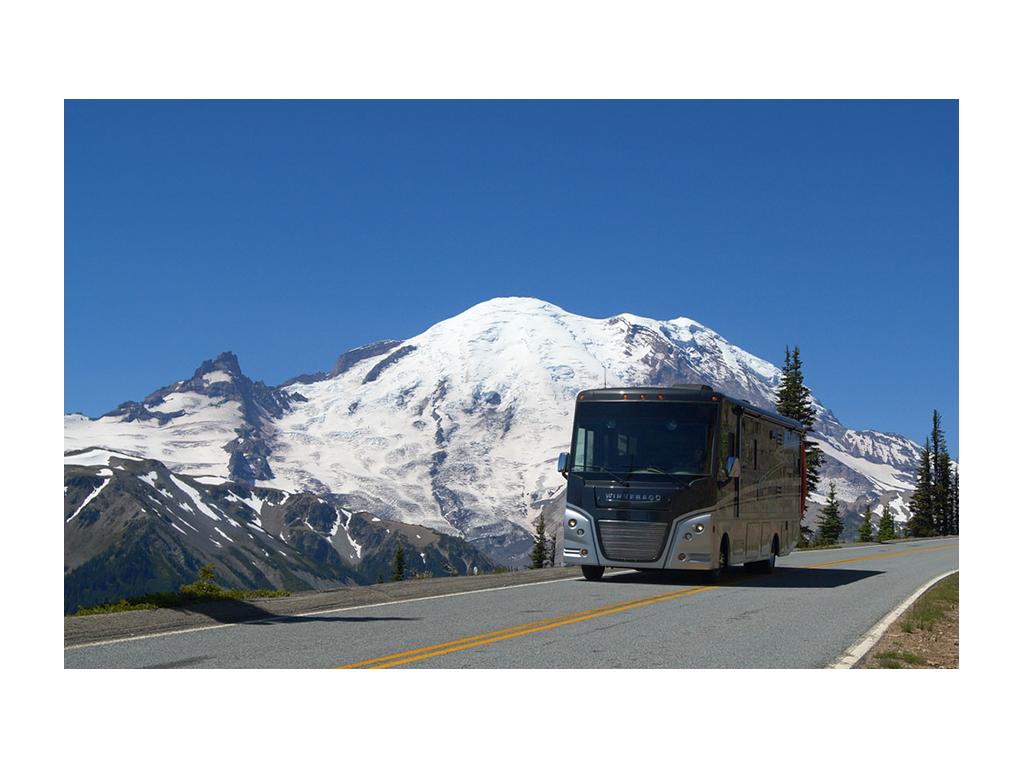Winnebago Adventurer driving down road in Mount Rainer National Park