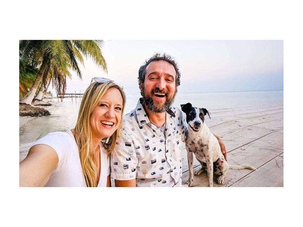 The Newstate Nomads sitting on dock with black and white dog on the beach