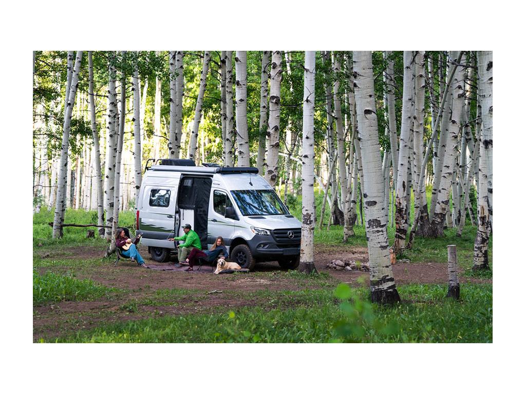 Abby, Peter, Kathy and yellow lab, Tucker, sitting outside of Revel with sliding door open.