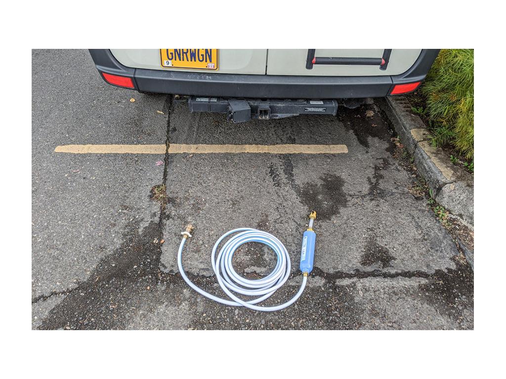 Gnar Wagon parked on road with water hose laying on ground behind it