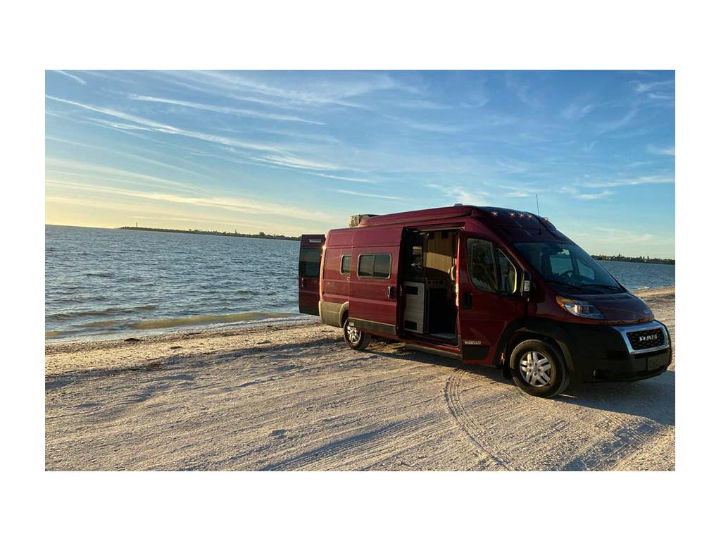 Solis parked on beach with back and side doors open