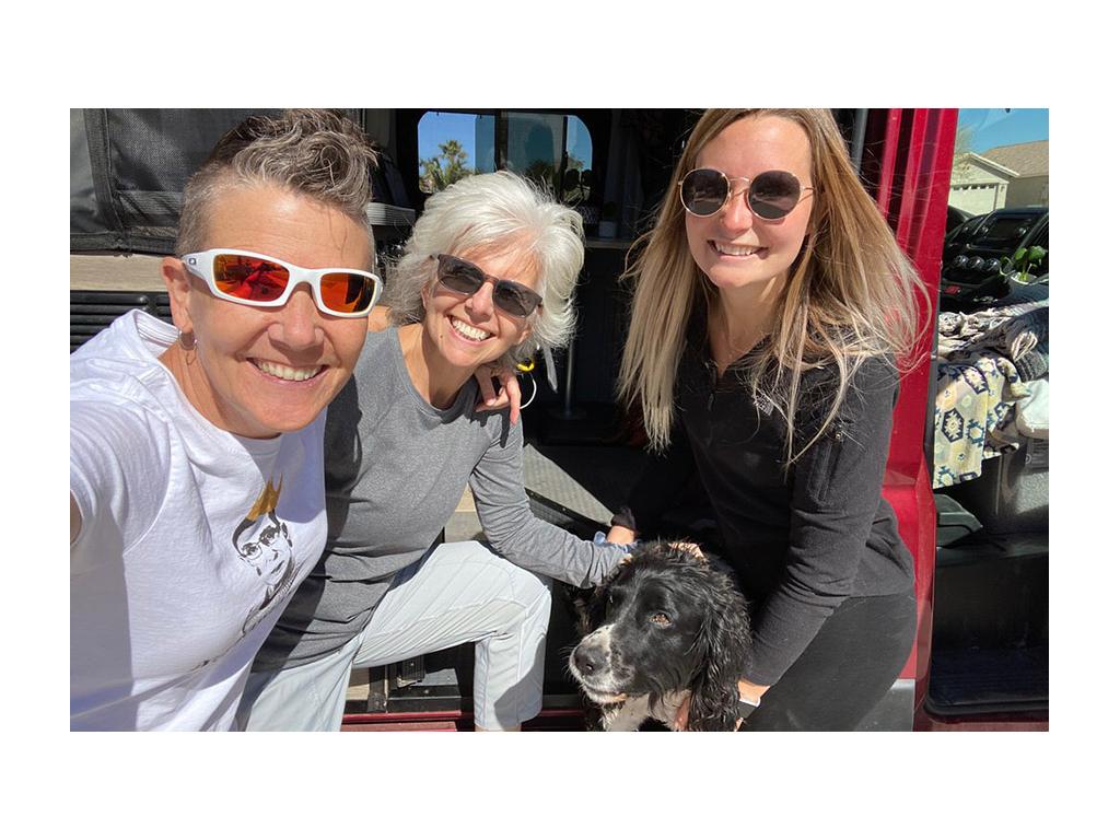 Noel and Chris smiling with a friend and dog in front of Solis