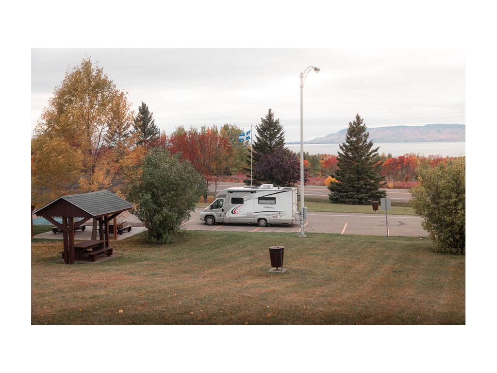 Trend parked in parking lot near pic table. Red fall trees in background.