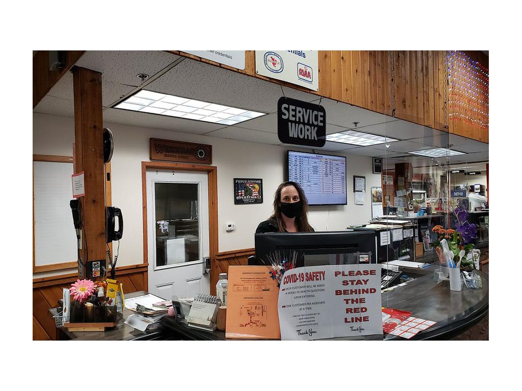 Winnebago employee wearing mask standing behind front desk