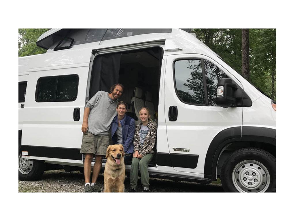 Jason, Kristen, Bennett the dog, and Mary Schmitt sitting in entrance of Solis