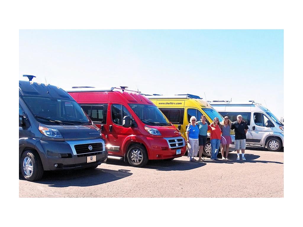 A group of WinnieBs huddled together in front of line of Travatos at GNR