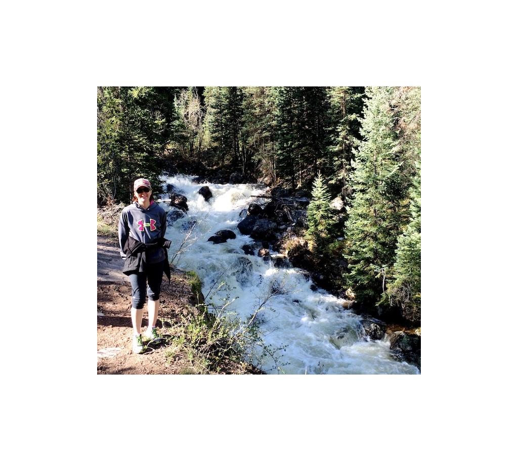 Kelli Harms standing next to a rushing creek.