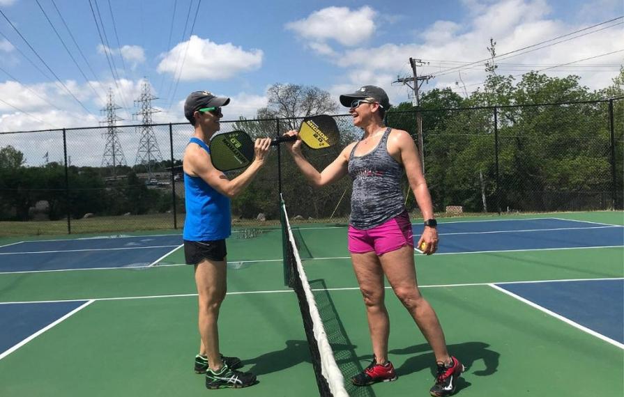 Ann and Lin tapping paddles before game