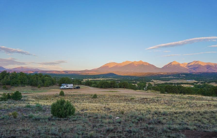 Navion parked in the distance with mountains in background