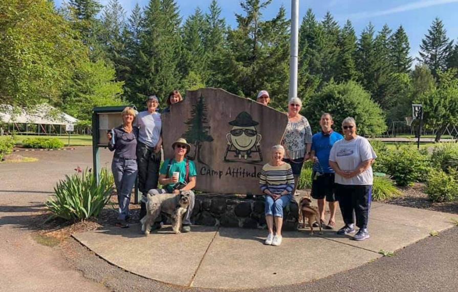 Travato owners gathered around Camp Attitude sign
