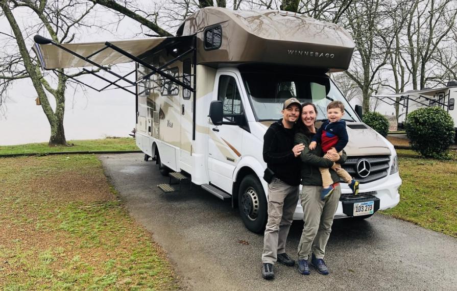 Highland family standing in front of Winnebago View with awning out