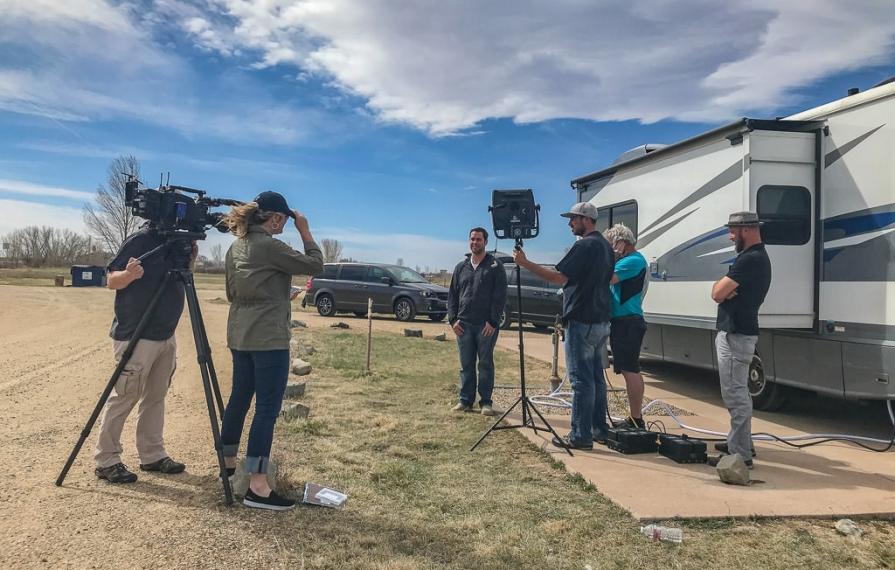 Film crew outside of RV with cameras