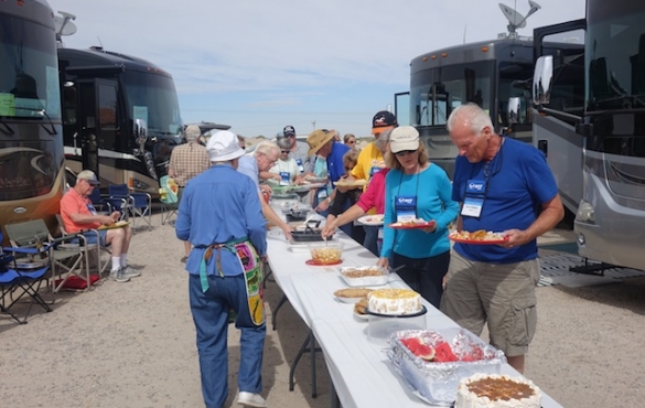 Tables set up potluck style between RVs.