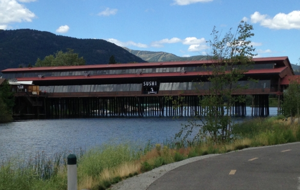 Bottom half of an old car with sign that reads "proud to be" with an American flag.