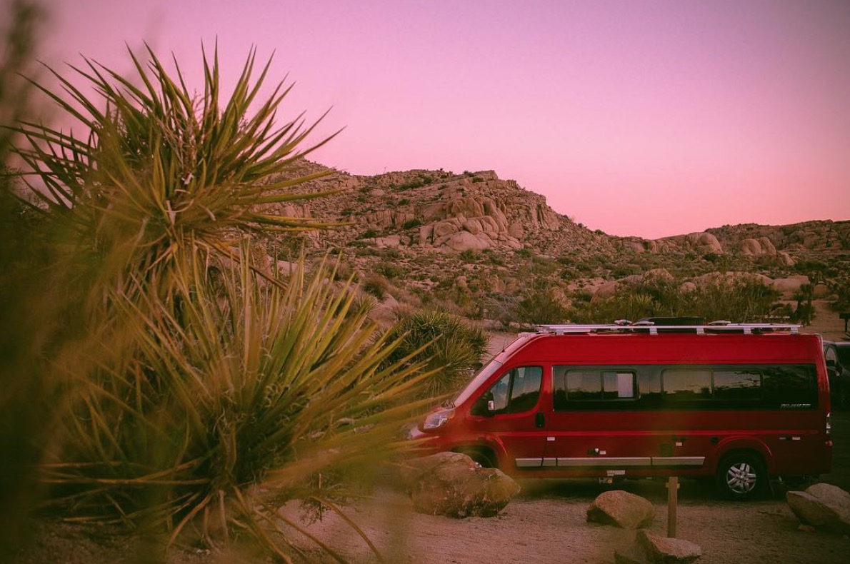 Winnebago Travato parked in desert landscape.