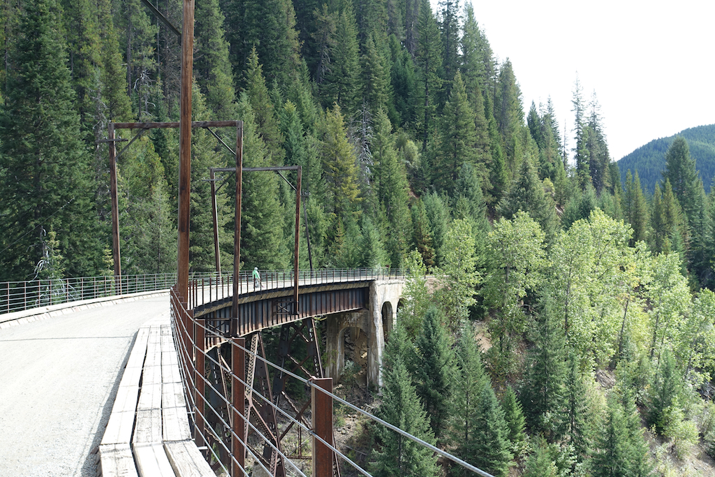 Biker crossing a trestle bridge above the valley.