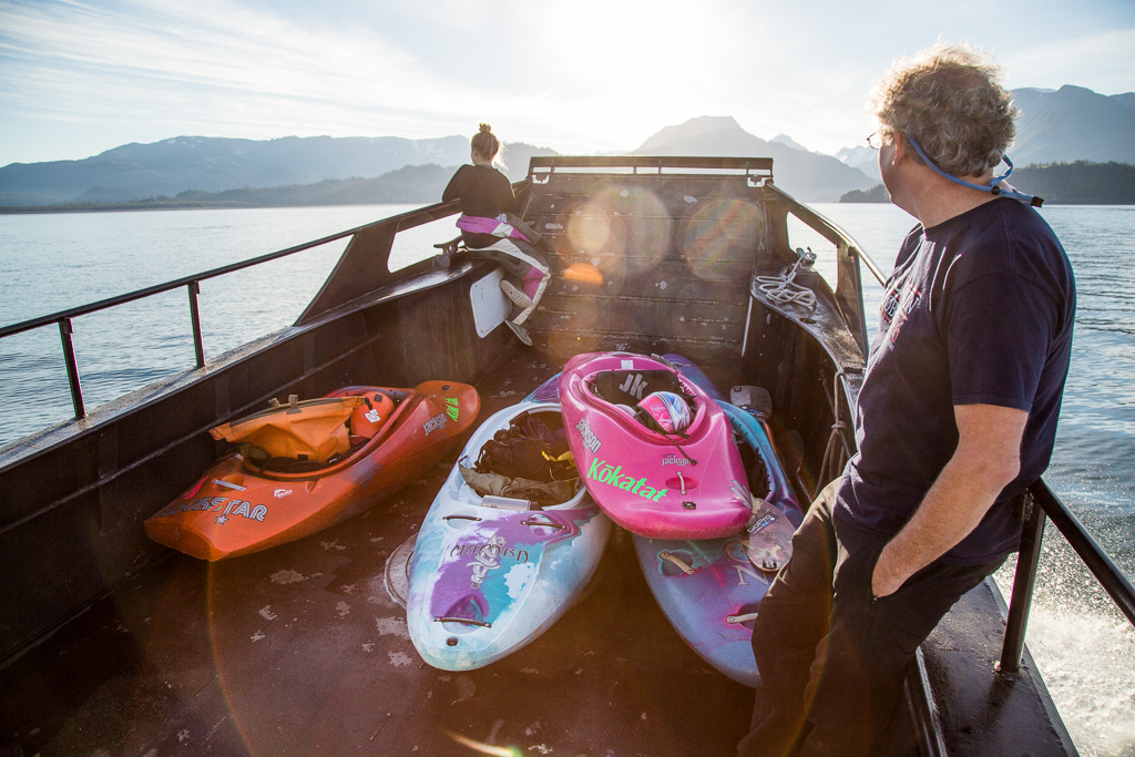 Abby and Randy sitting at the front of a boat with kayaks.