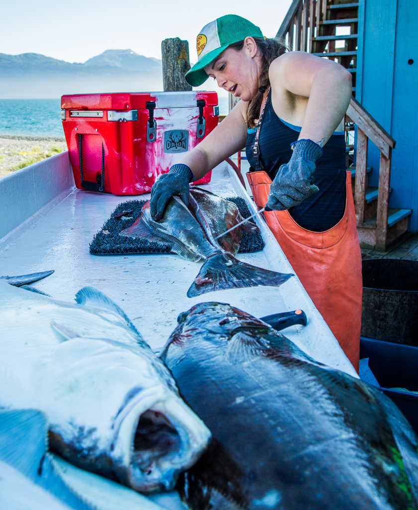 Woman filleting a fish.