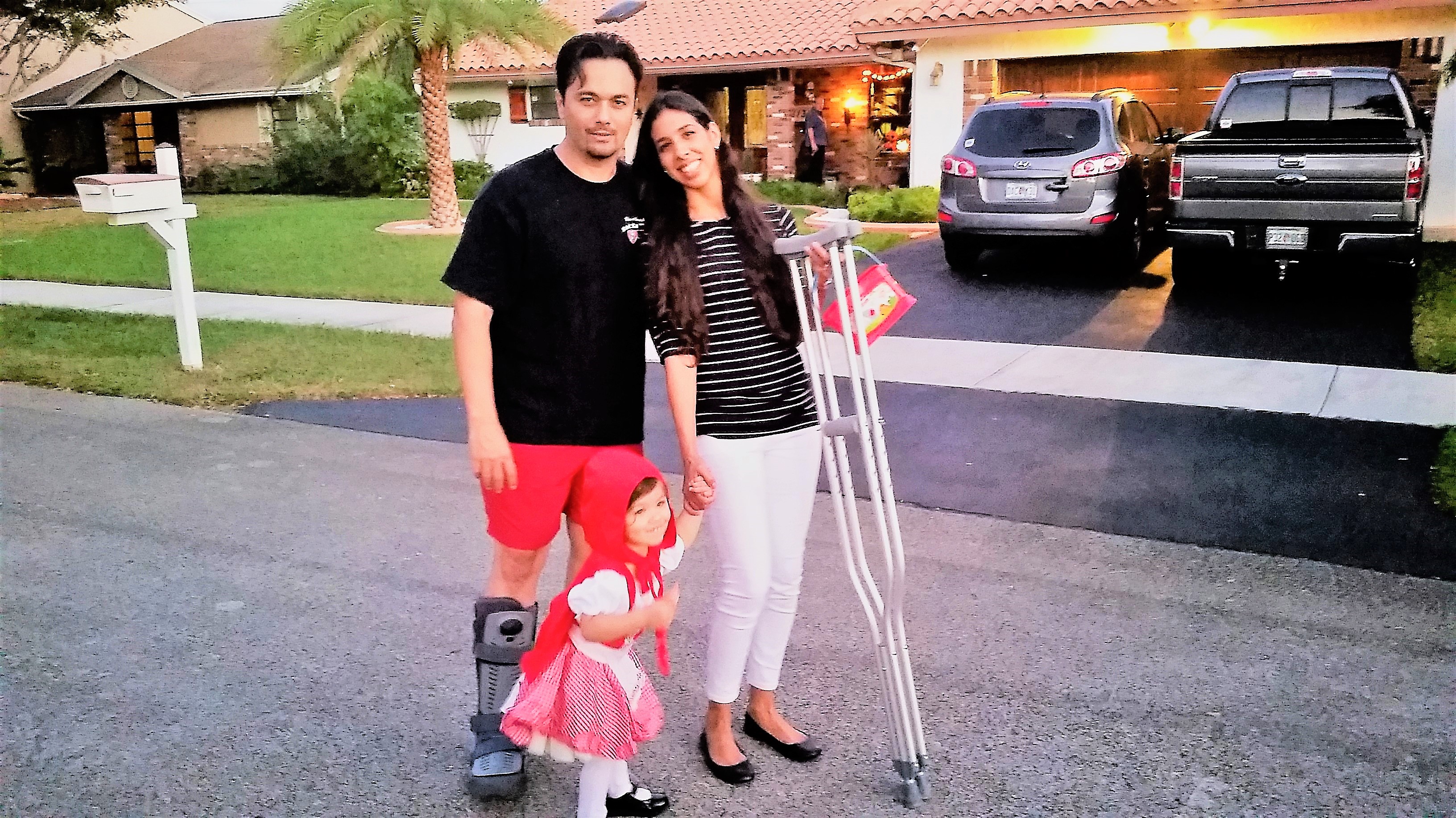 Couple dressed up for Halloween in front of a house.