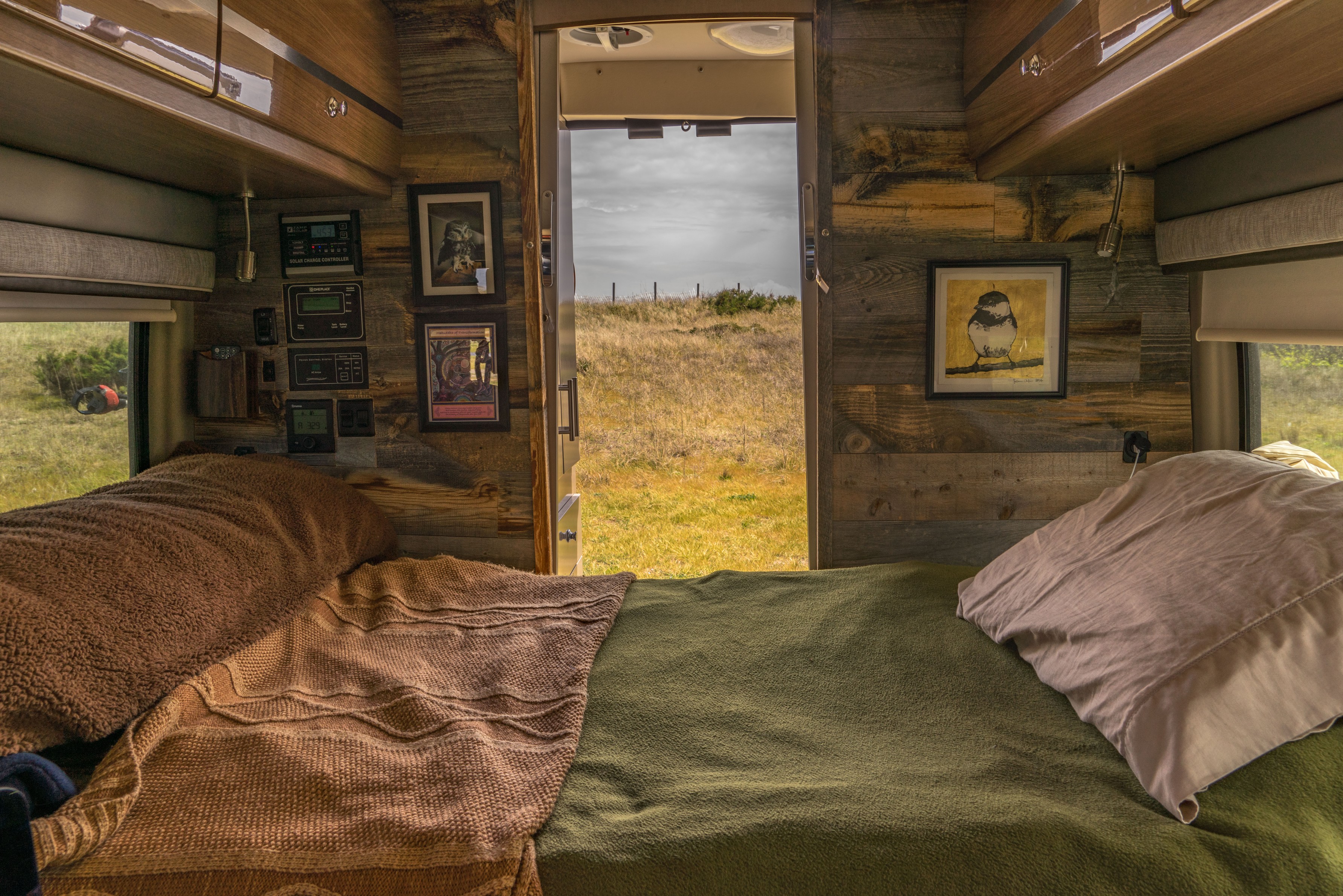 Bed set up in rustic decorated Winnebago Travato.