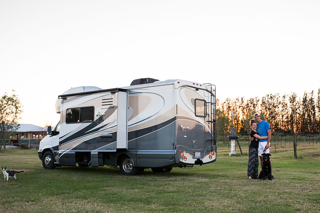Jordan and Brittany standing with their dog outside their Winnebago View.