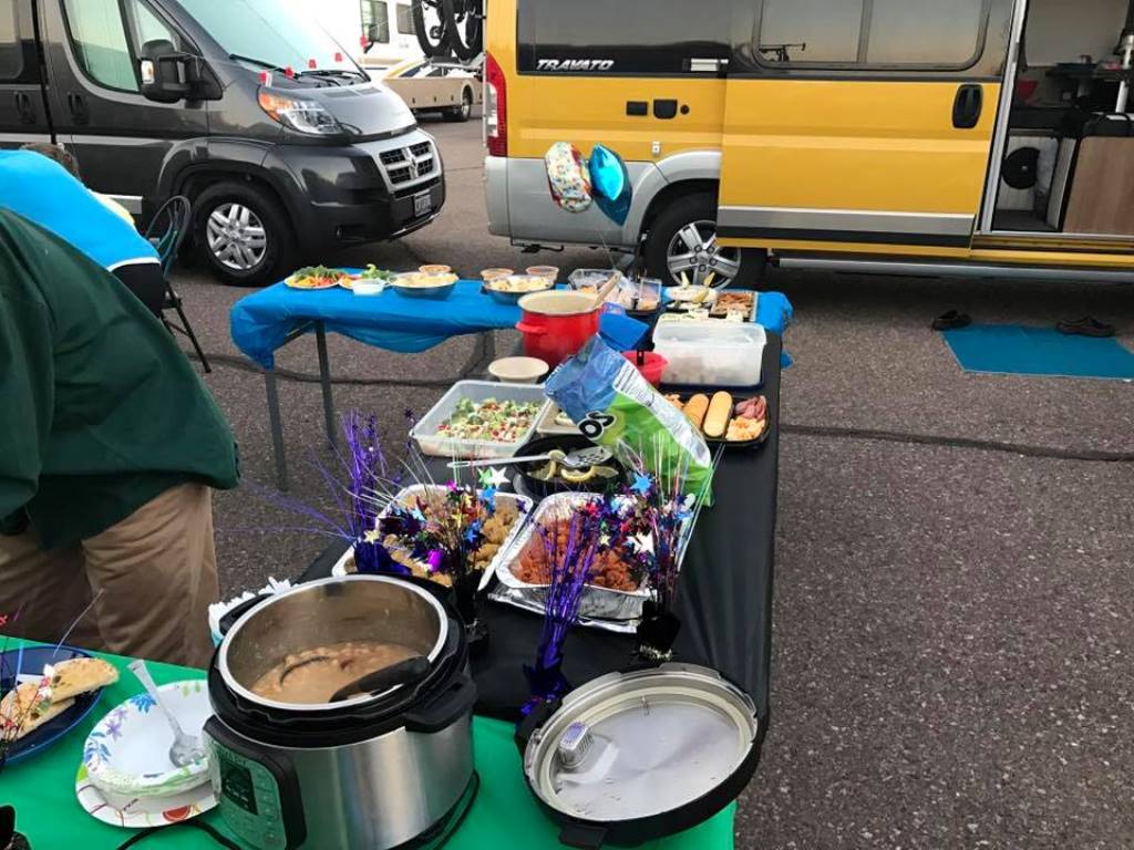 Buffet of food set up outside Winnebago Travato.