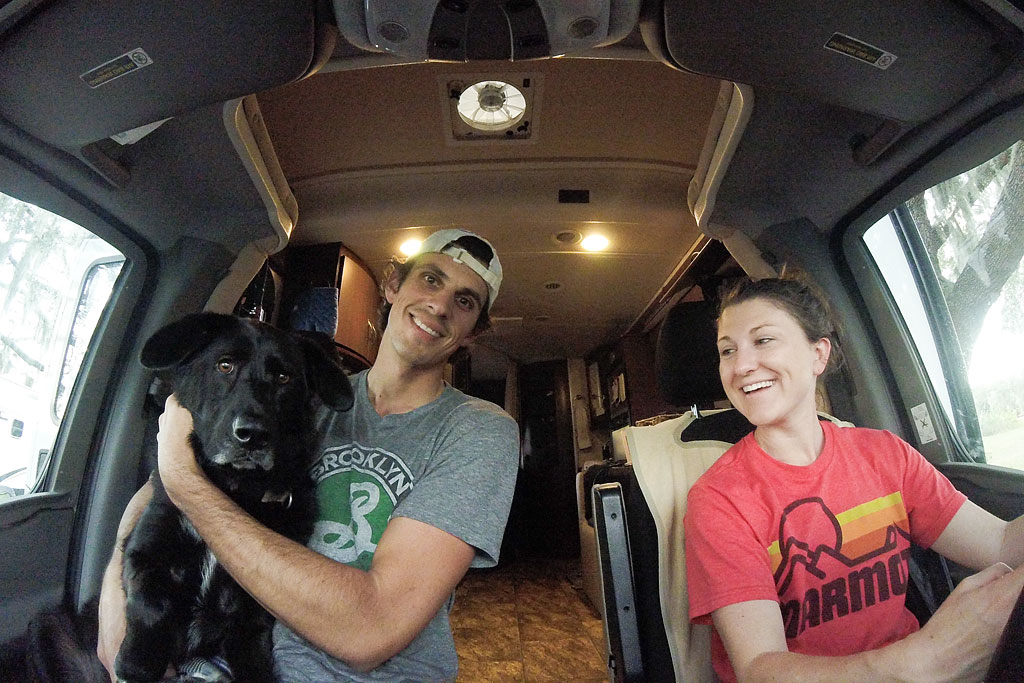 Brittany driving the Winnebago View with Ella sitting on Jordan's lap in the passenger seat.