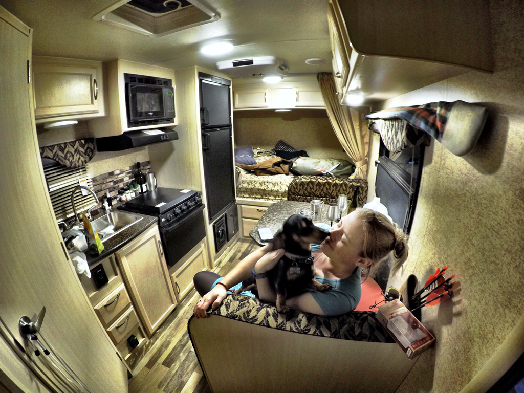 Woman and dog in dinette of Winnebago Micro Minnie.