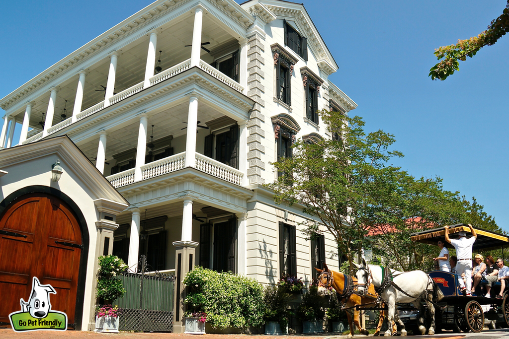 Old building with horse drawn carriage out front. 