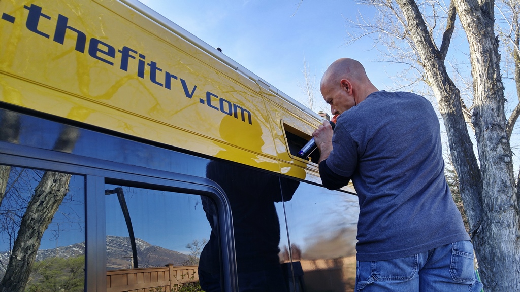 James working on the exterior of his Winnebago Travato.