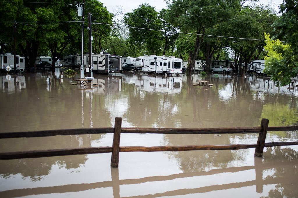 Flooded campground with water rising up to RVs.
